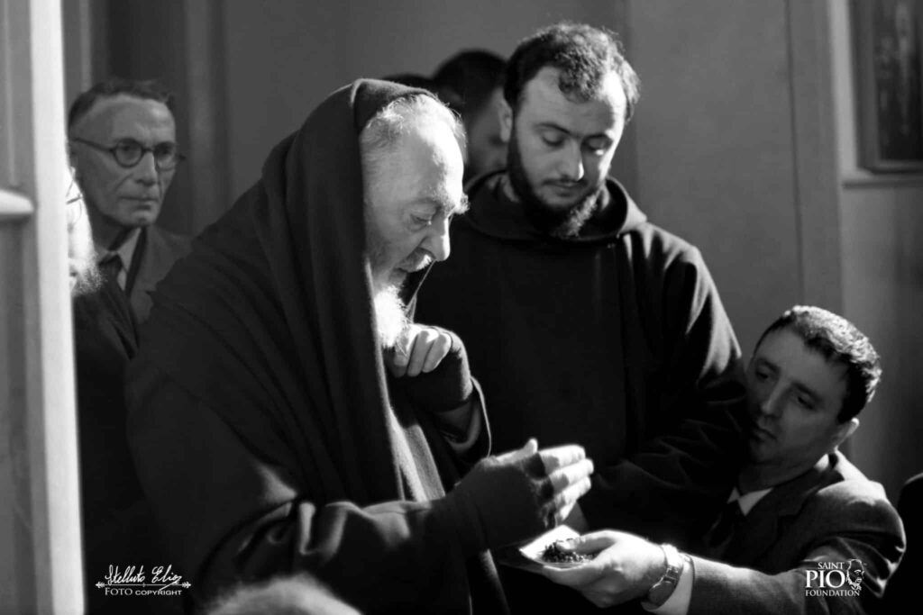 Saint Padre Pio blesses the Eucharist during Mass in Italy.