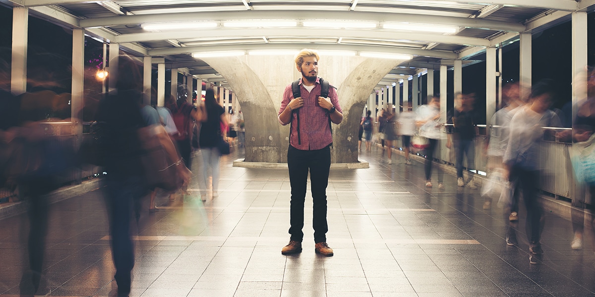 man standing still in rush hour.