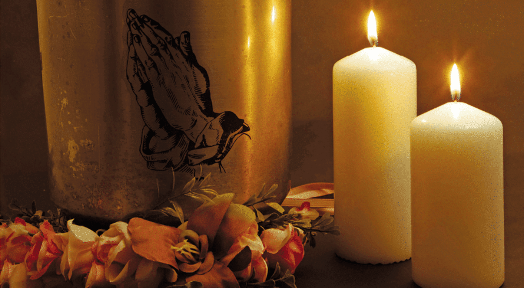Candles and flowers next to an urn